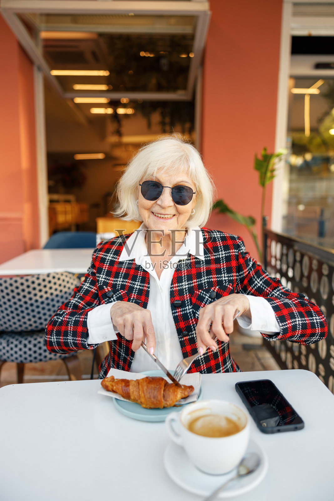 美丽的老妇人在户外咖啡馆吃饭照片摄影图片