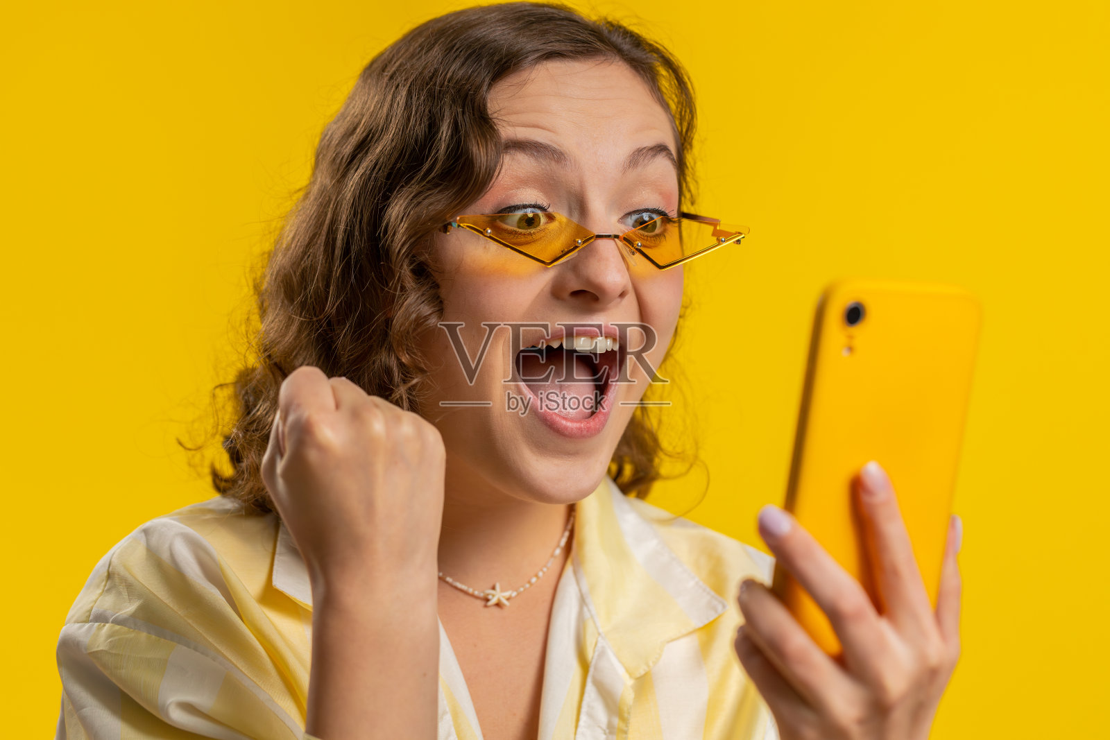 开心兴奋的中奖者用智能手机说，哇，是的，发现了巨大的中奖好消息彩票照片摄影图片