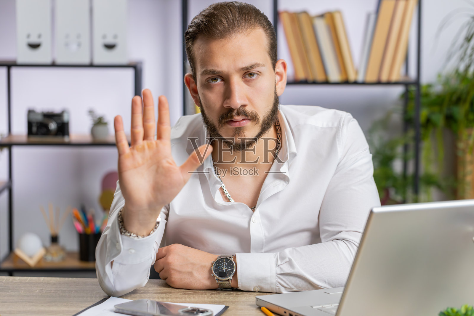 用笔记本电脑工作的商人做出停止手势，表示危险、拒绝、警告、危机、禁止照片摄影图片