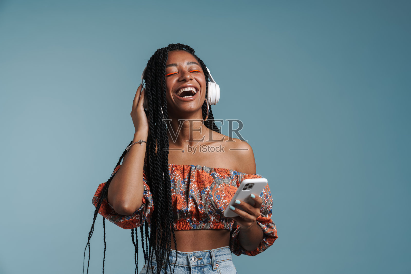 年轻的黑人女性一边戴着耳机听音乐，一边唱歌照片摄影图片