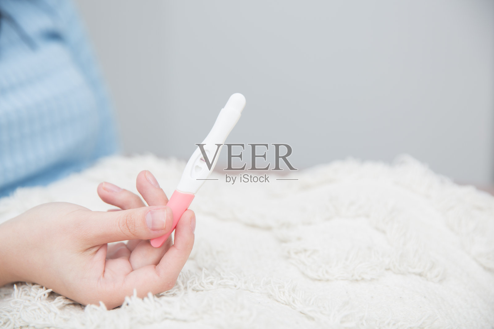 一名妇女用一条线拿着验孕棒照片摄影图片