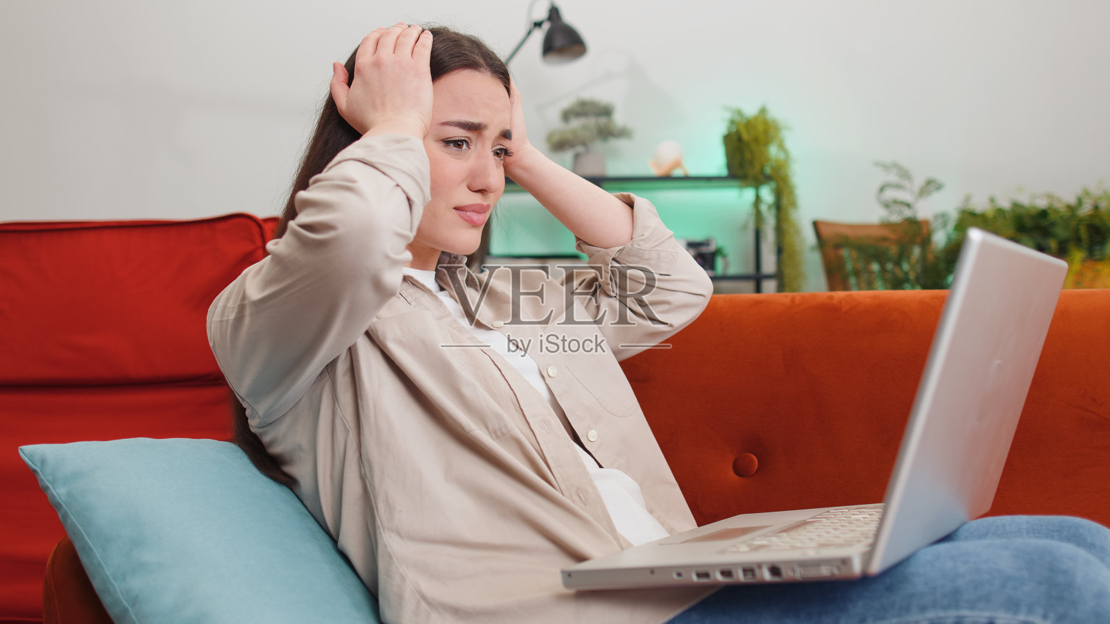 漂亮的年轻女子使用笔记本电脑惊讶于坏消息，财产损失，失败，彩票结果在家里照片摄影图片