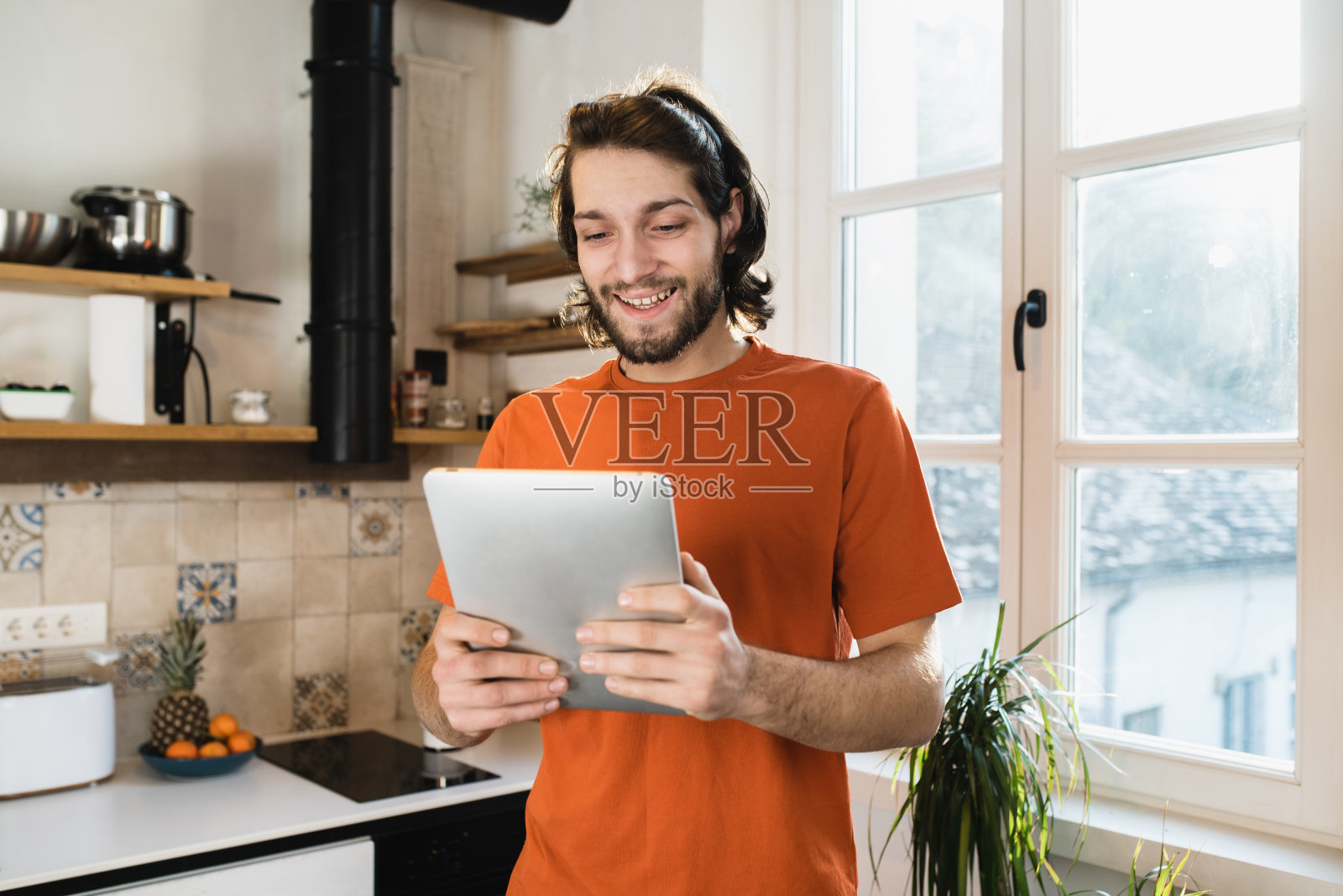 快乐的年轻人在家里享受，在平板电脑上上网照片摄影图片