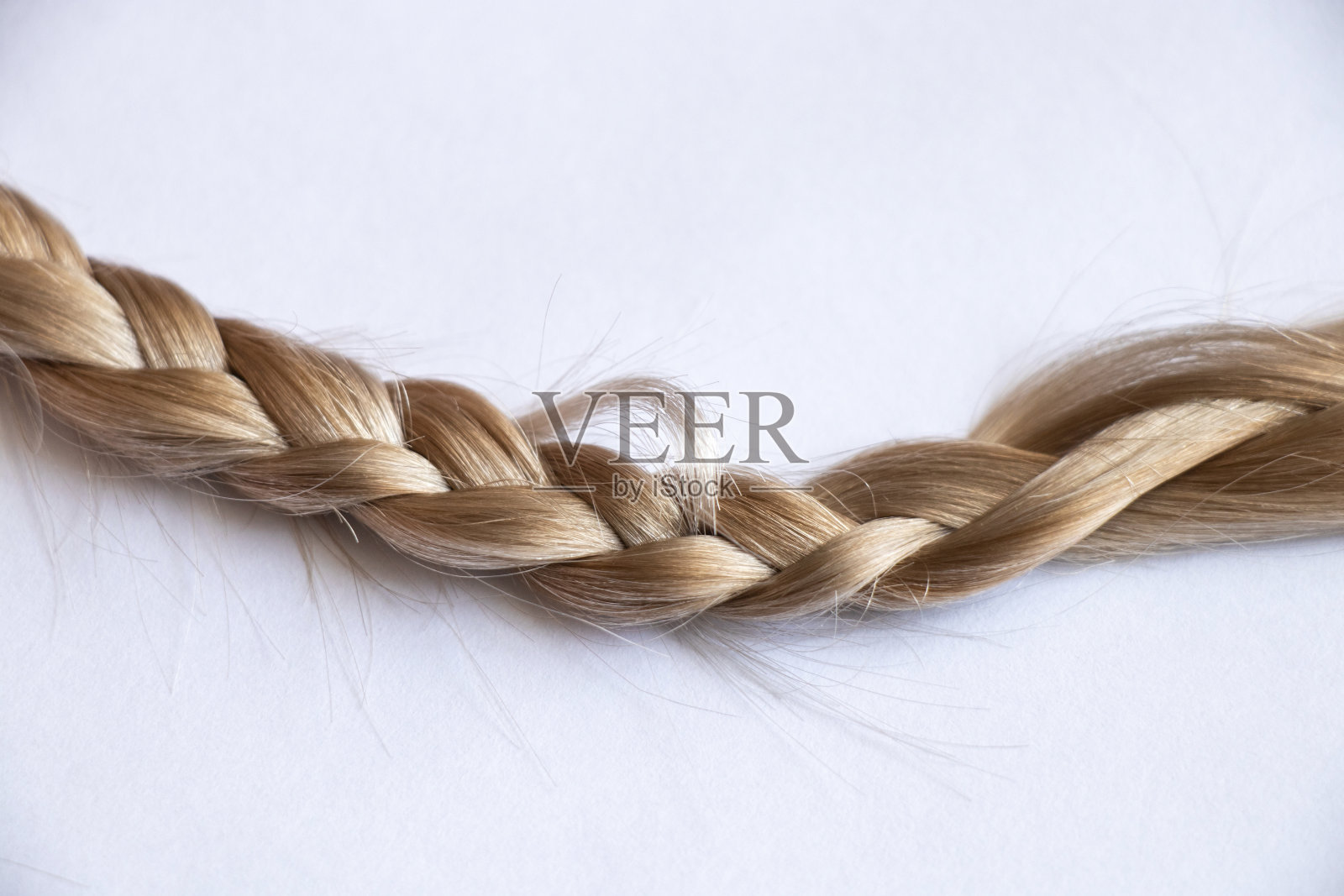 白色背景上的金发辫子特写照片摄影图片