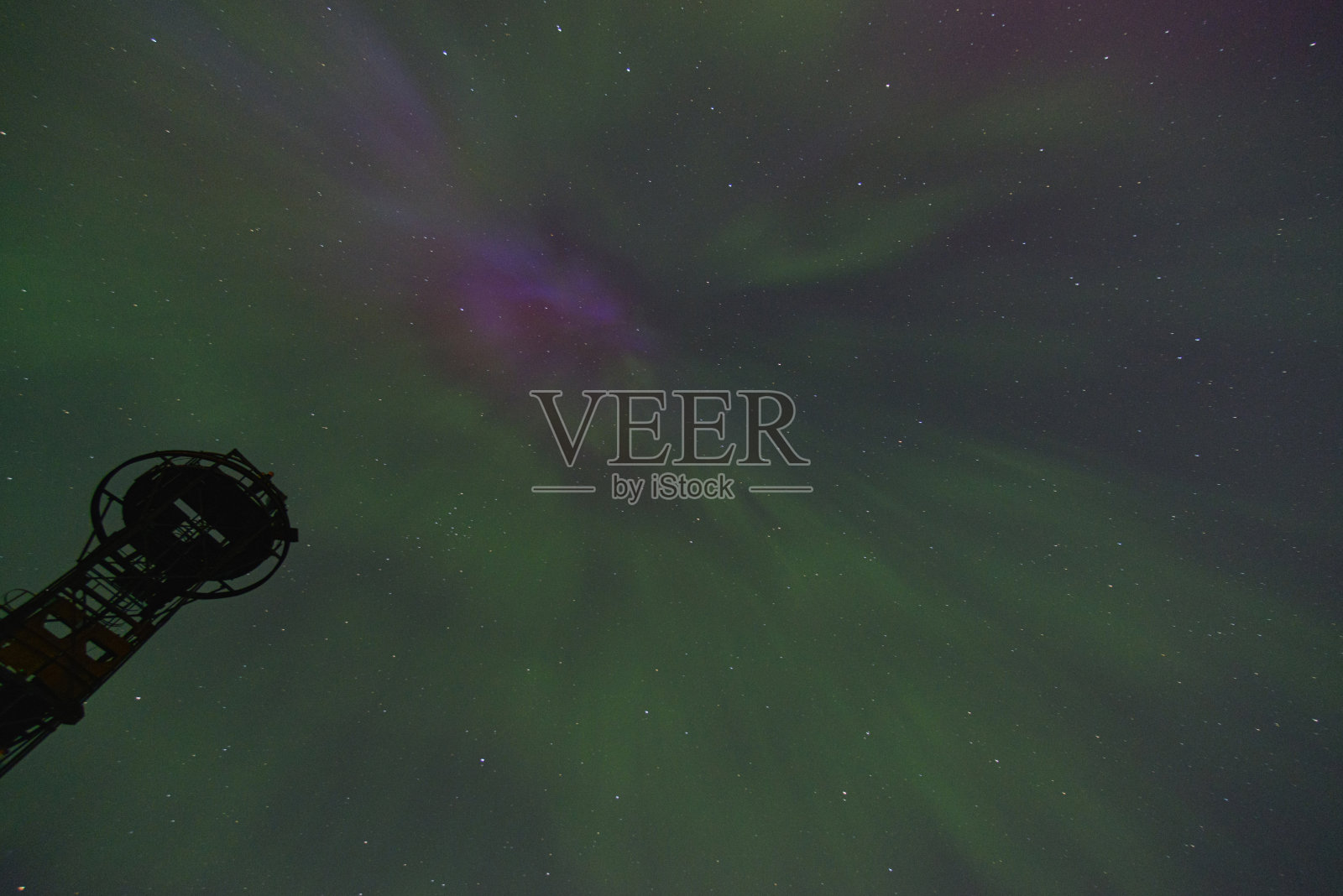 绿色和紫色的北极光在夜晚的星空照片摄影图片