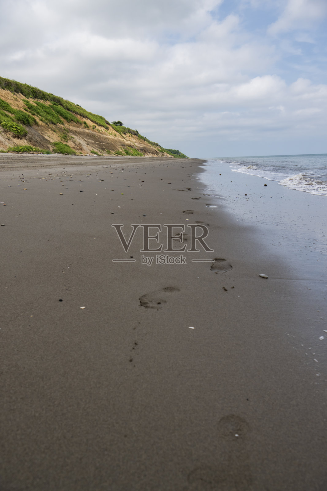 北海海岸的沙滩上，沙滩上有脚印照片摄影图片