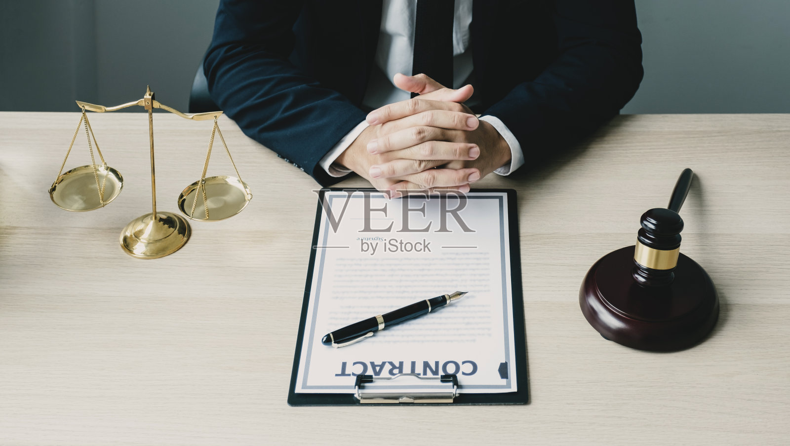 律师在办公室提供法律咨询，处理商业纠纷，配有正义天平和法槌照片摄影图片