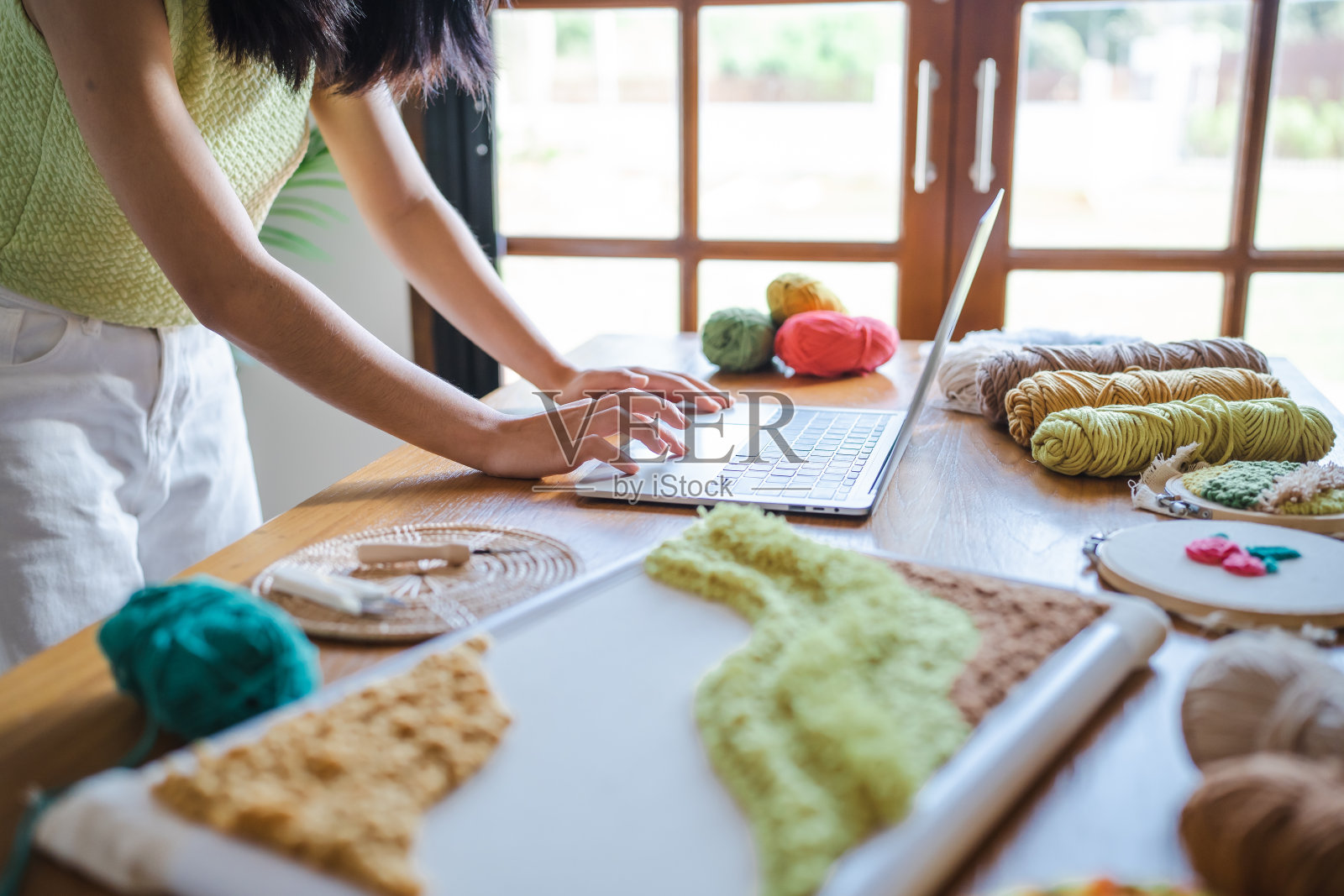 小企业：微笑的亚洲女创业者，工作室里使用电脑的刺绣手工艺人照片摄影图片