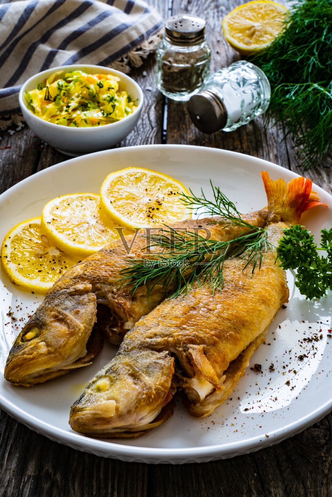 鱼菜——木桌上的柠檬炒鲈鱼照片摄影图片