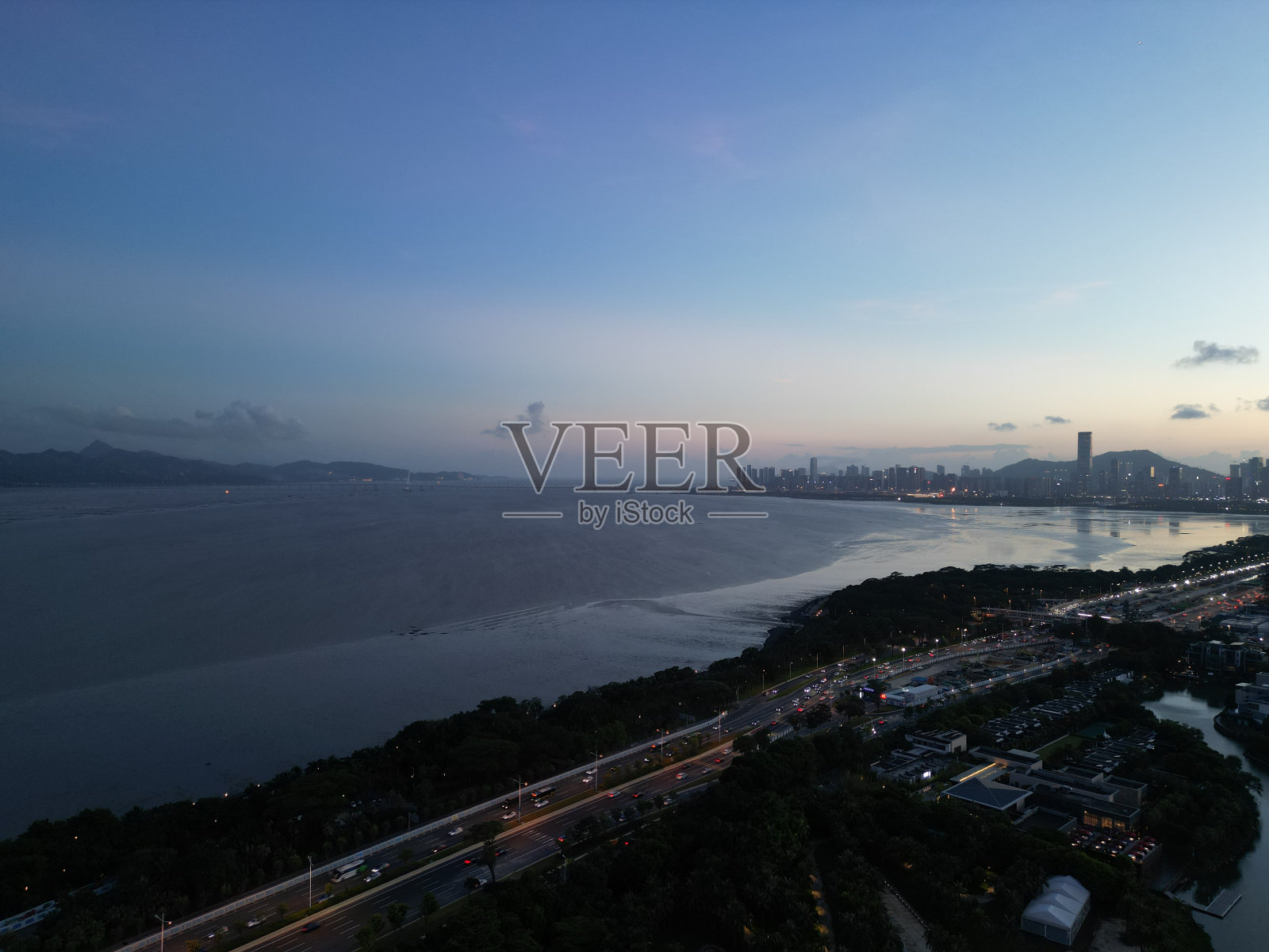 从航拍的角度看，海滨城市的晚霞照片摄影图片