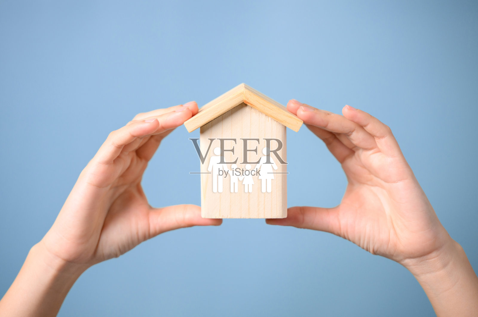 双手捧着木屋带着虚拟的家庭，爸爸妈妈和孩子一起拥有医疗和人寿保险，家庭保障，家庭生活方式照片摄影图片