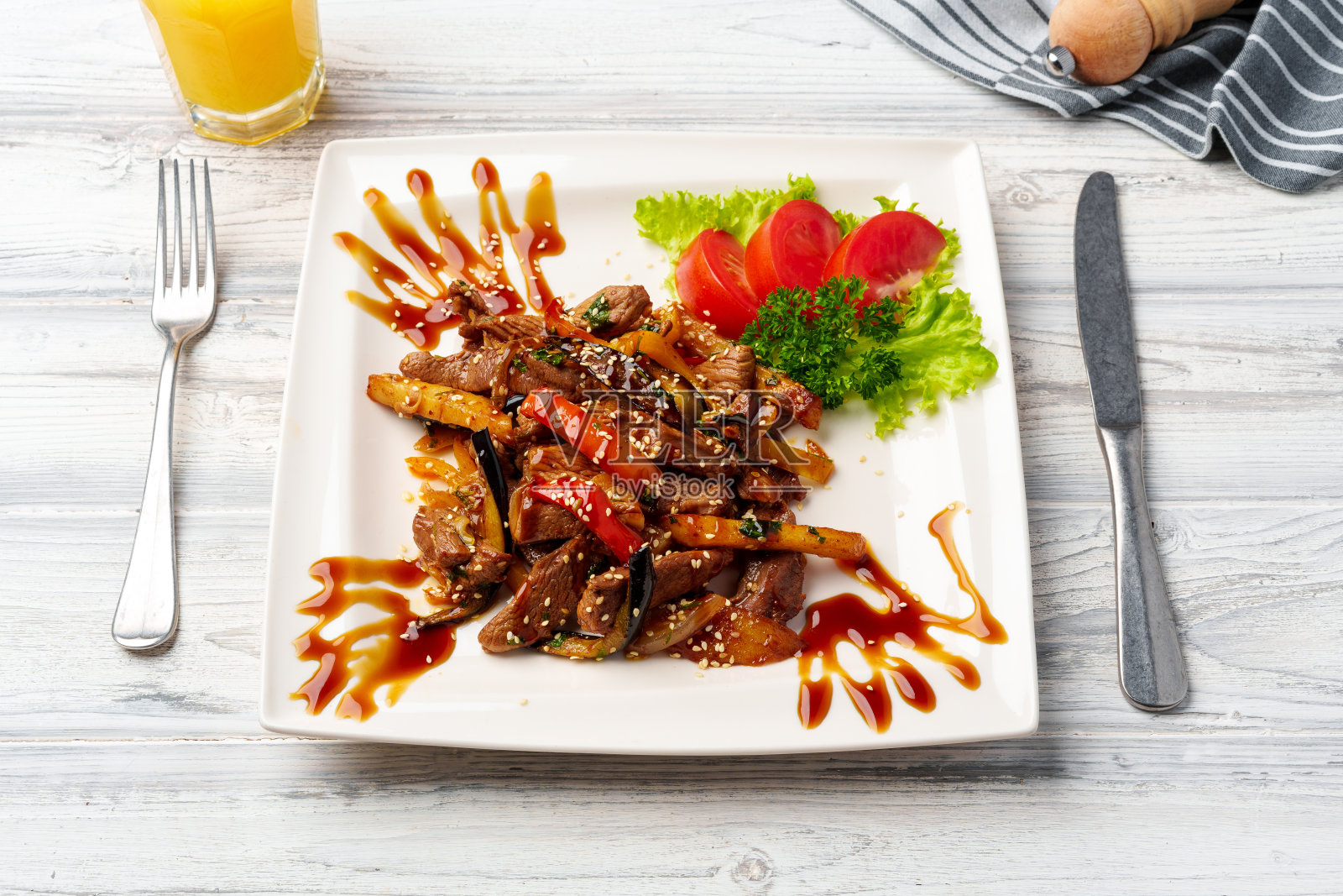 牛肉和蔬菜在木桌上的白色盘子里翻炒照片摄影图片