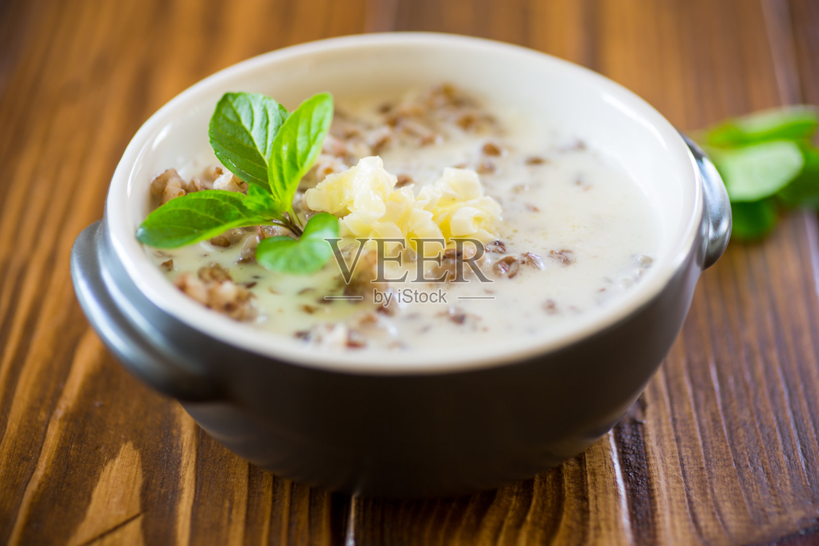 早餐用碗煮荞麦加牛奶和黄油照片摄影图片
