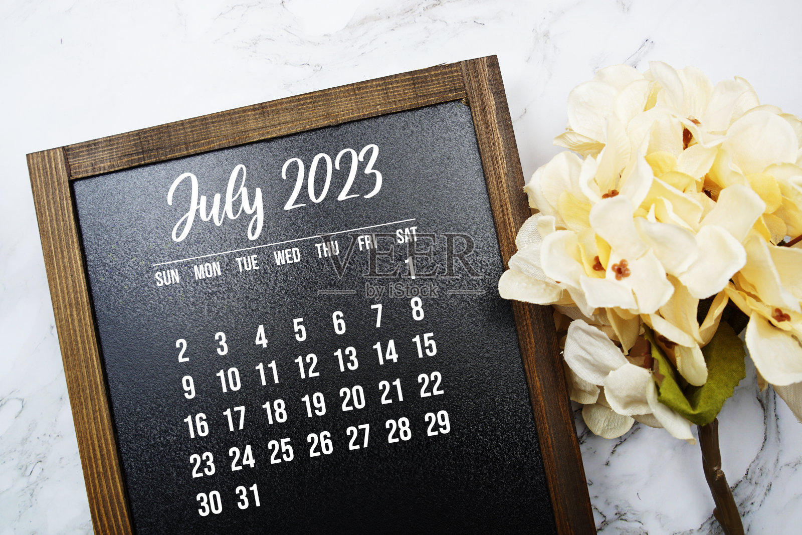 2023年7月月历与花束装饰大理石背景照片摄影图片