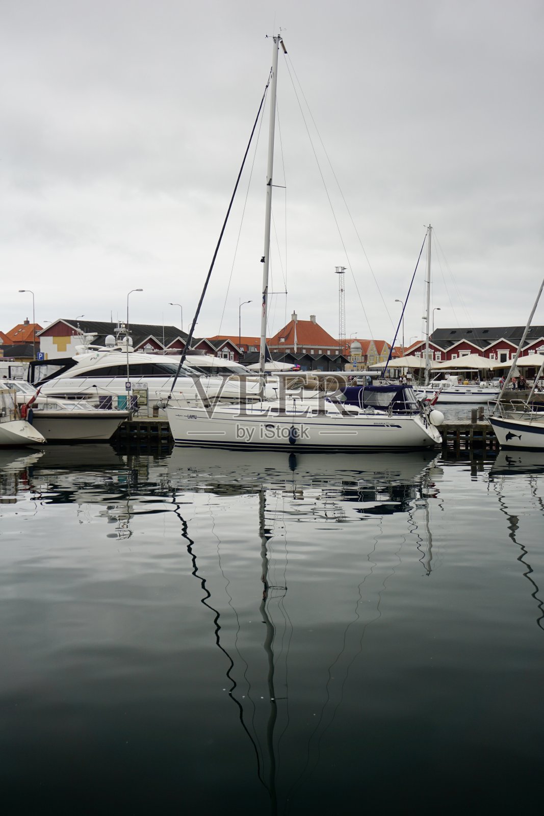 丹麦斯卡恩的停船站。在一个灰色的日子里，停车场里的船在海上的倒影。游艇停在斯卡恩。在一个灰色的多云的日子里，船在水中的倒影。照片摄影图片