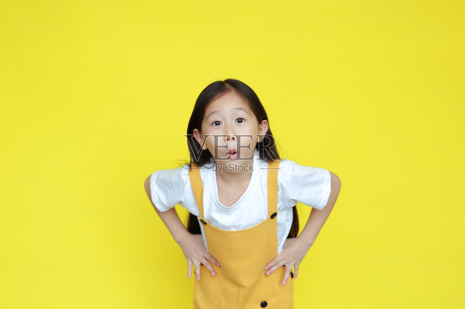 有趣的脸小女孩惊人的表情孤立在黄色的背景。亚洲小孩做着兴奋的手势照片摄影图片
