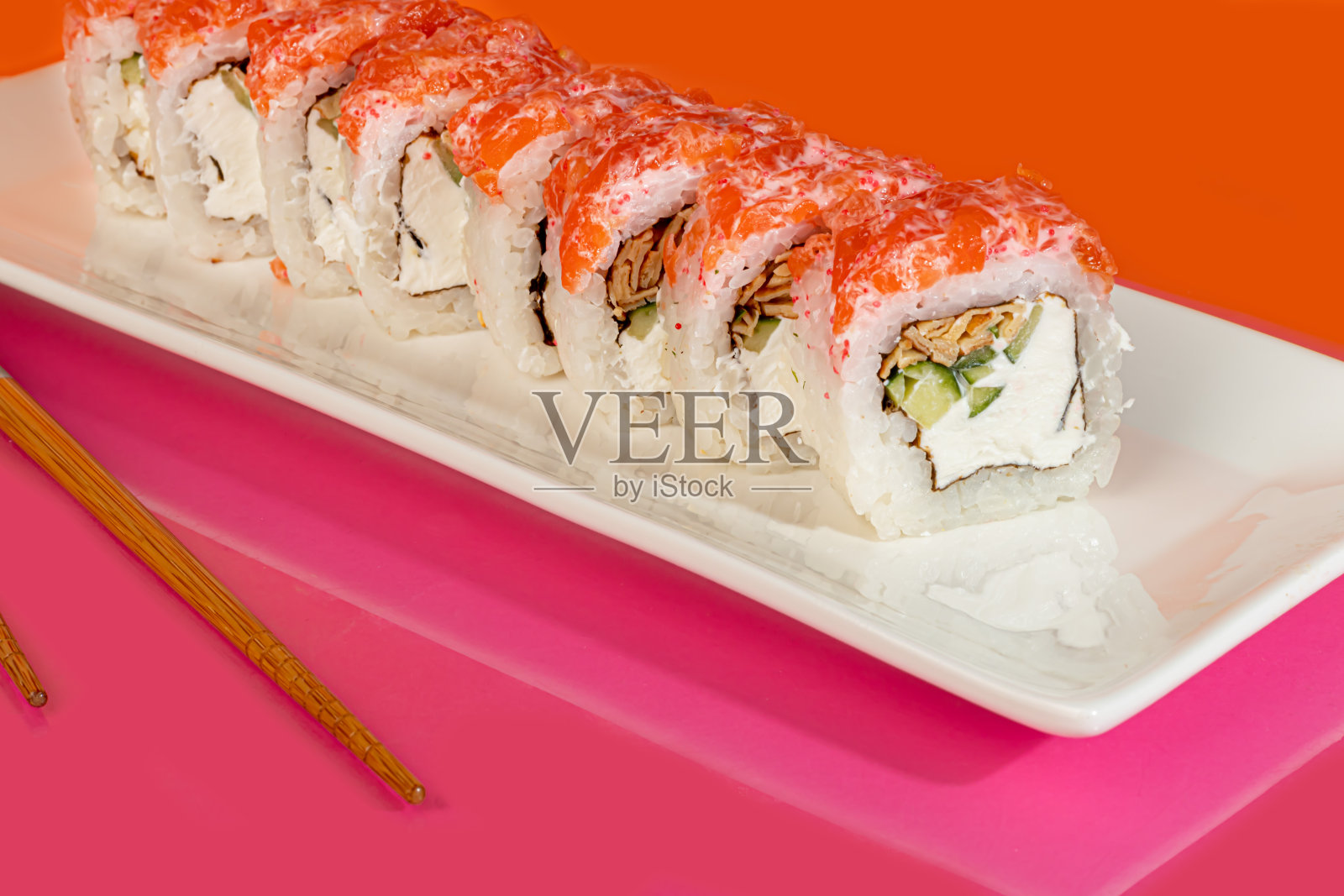 寿司套装，鱼子酱卷，虾，金枪鱼，鳄梨和费城奶酪，在一个白色的盘子里。照片摄影图片