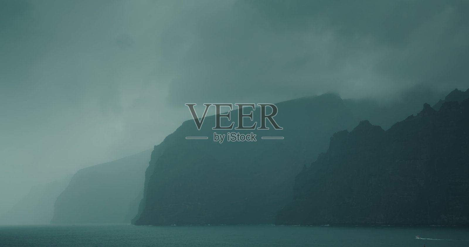 灰暗的海洋景观和灰色的风暴云。雾笼罩着海岸上高高的海崖。神秘的雾霾激发了恐惧和伟大。照片摄影图片