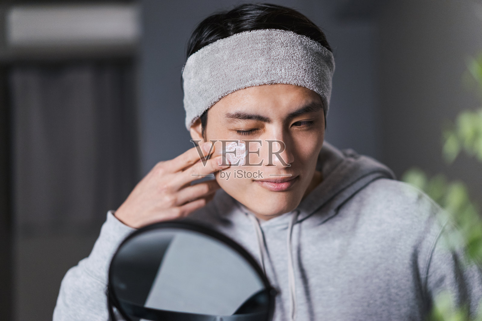 一个30岁的男人，用天然的天然有机化妆品照镜子(男性美的形象)照片摄影图片