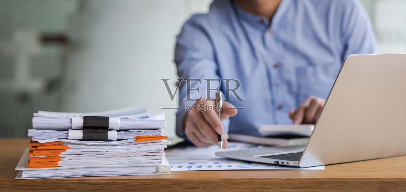 商务人士在办公桌上处理商务报告，用计算器分析财务图表，制定会计财务报表。照片摄影图片