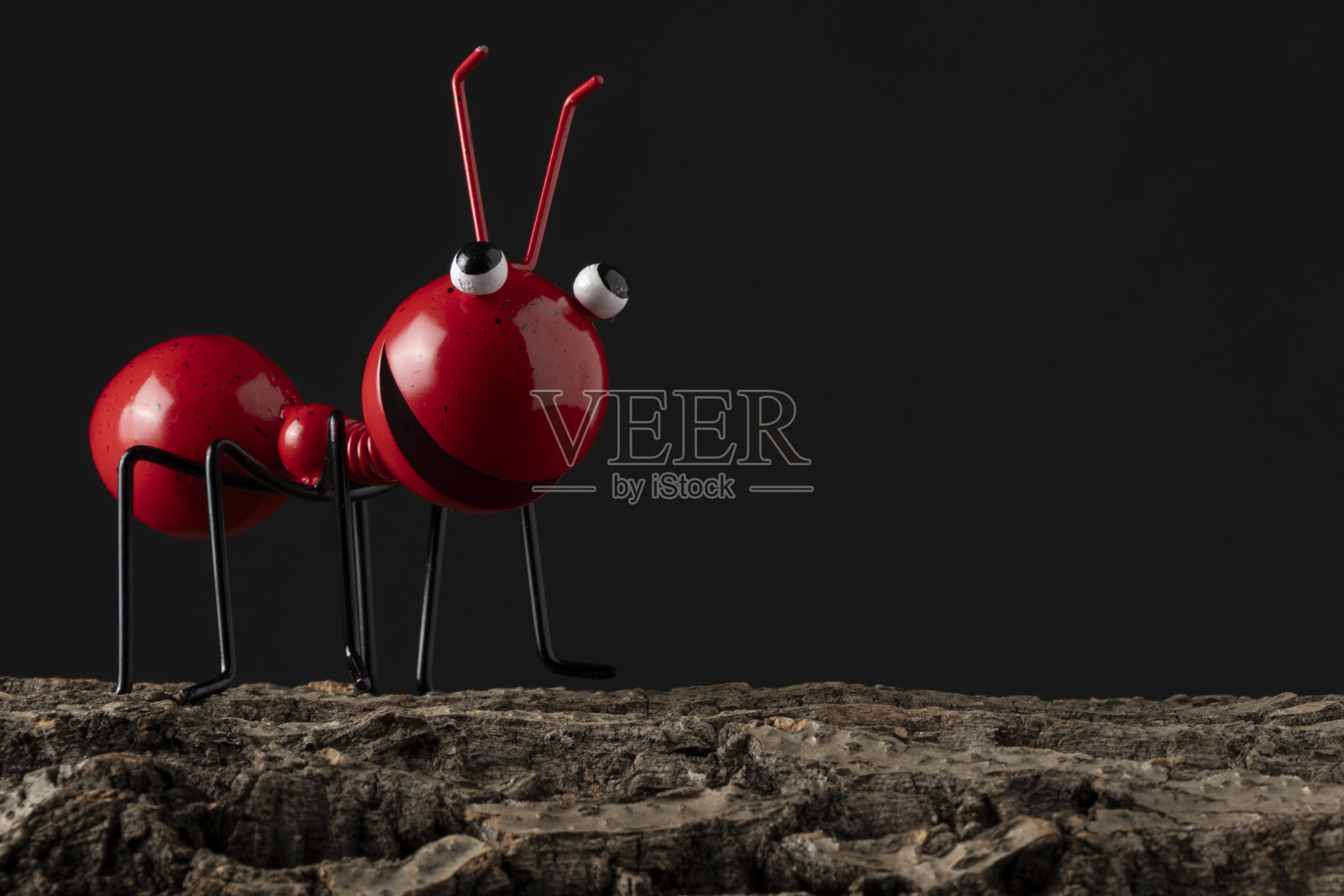 金属自制红蚂蚁在软木树皮上照片摄影图片