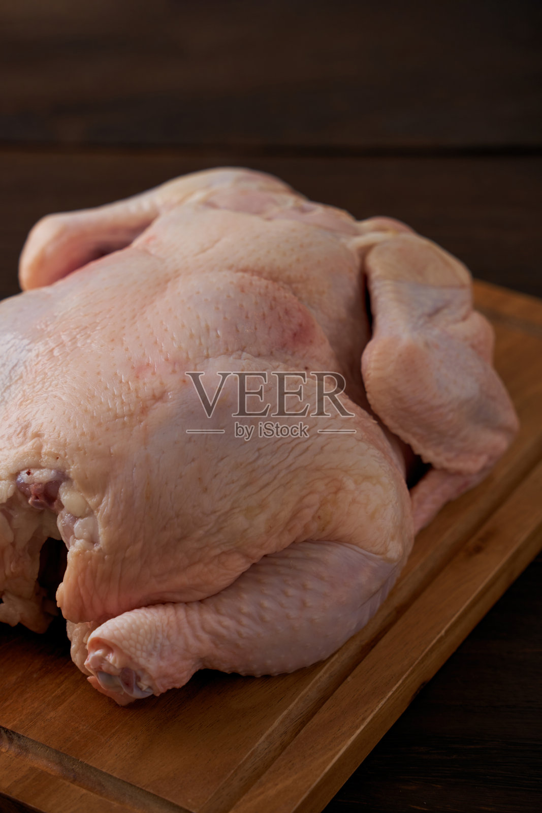 生鸡肉放在砧板上照片摄影图片