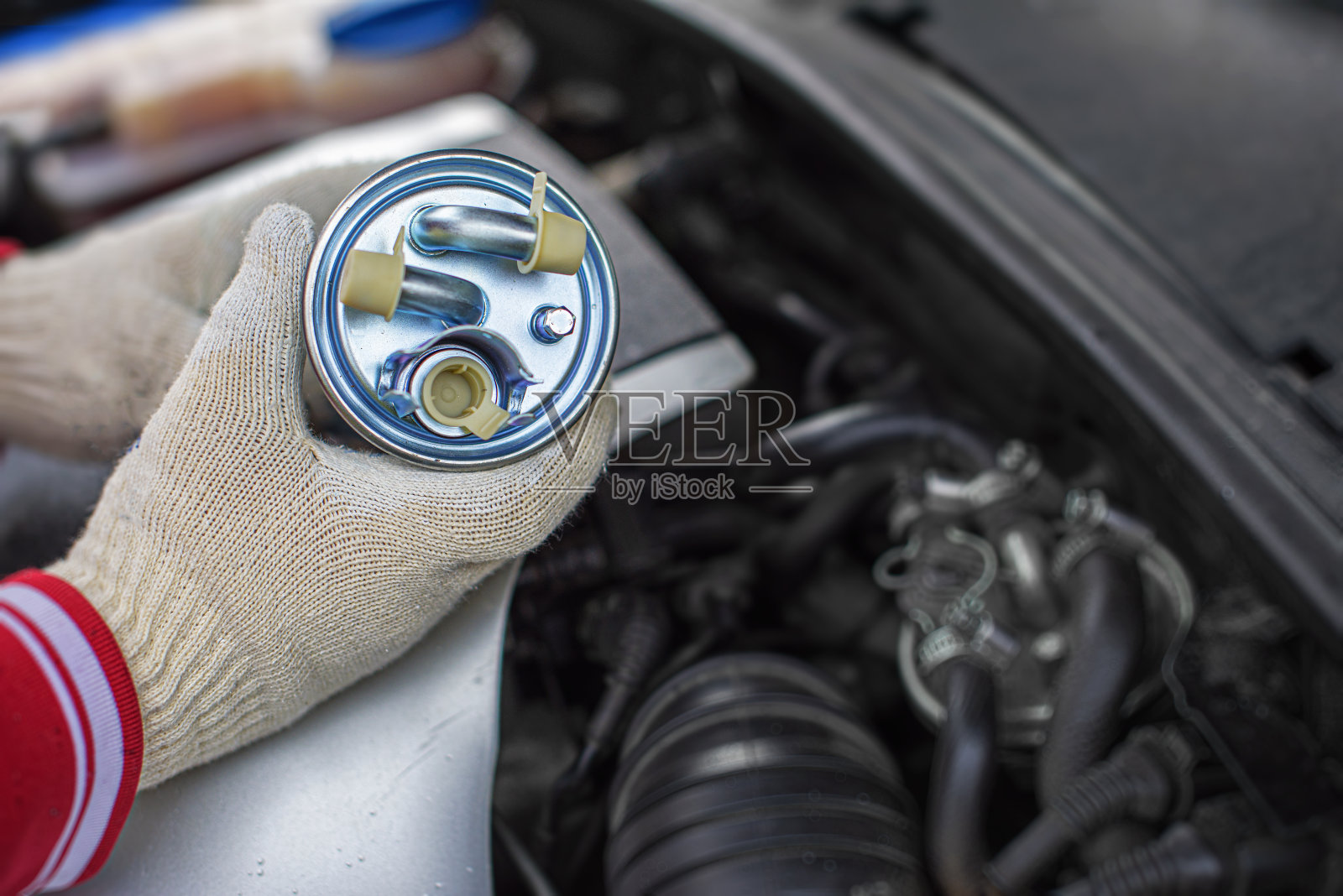 更换汽车燃油滤清器。照片摄影图片