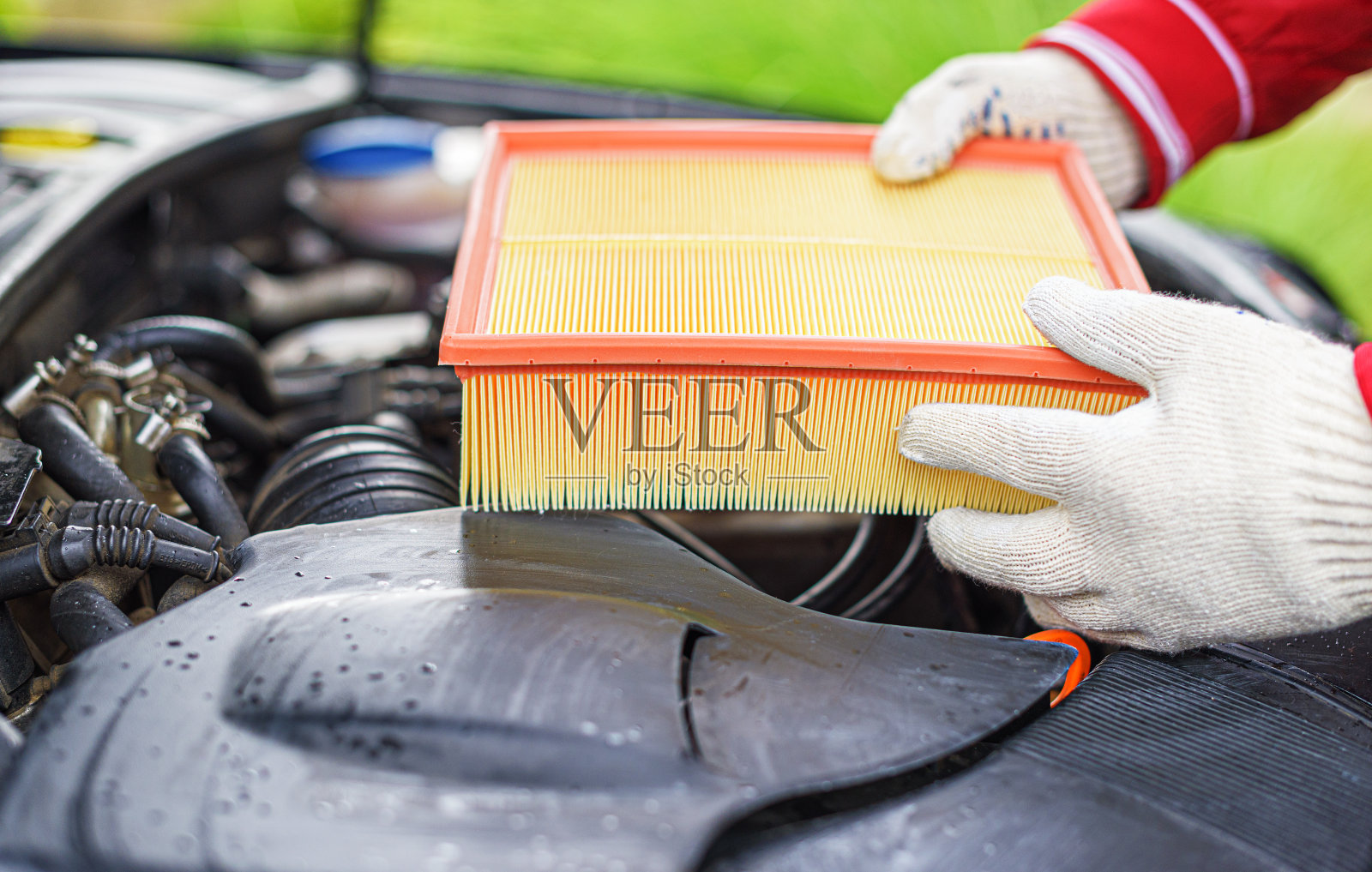 车辆保养时更换汽车发动机上的滤清器。照片摄影图片