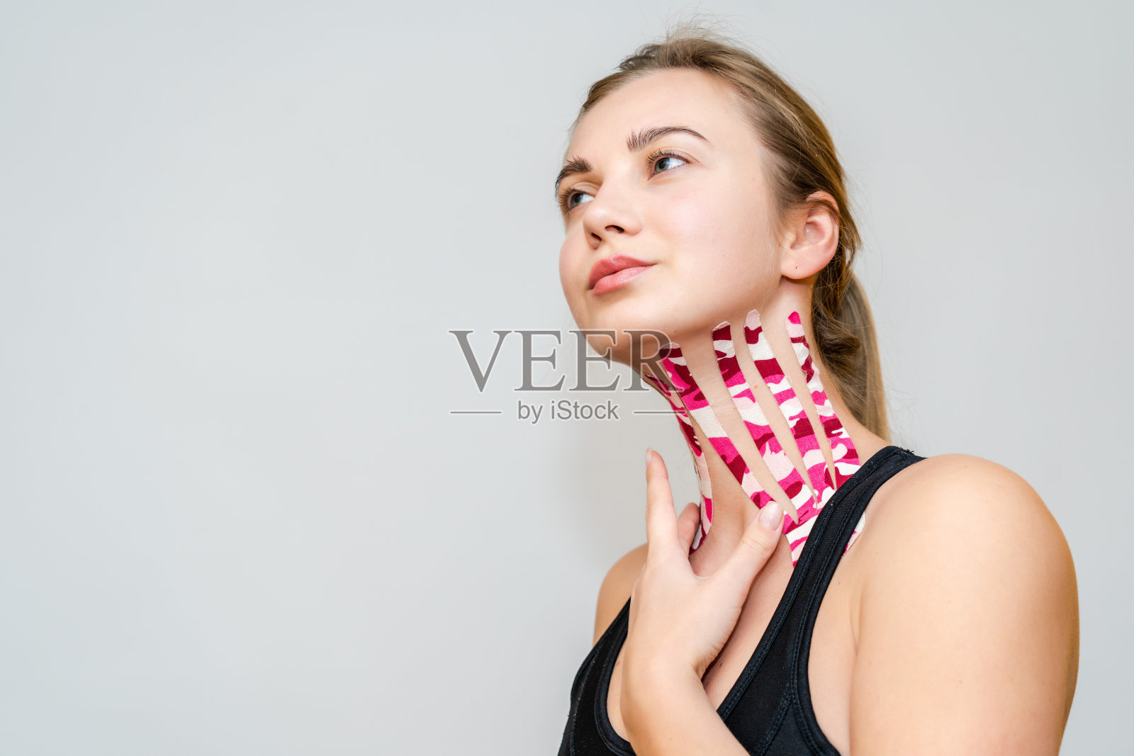 年轻女子用胶带做肌肉收缩拉皮术。审美录制。沙龙照片摄影图片