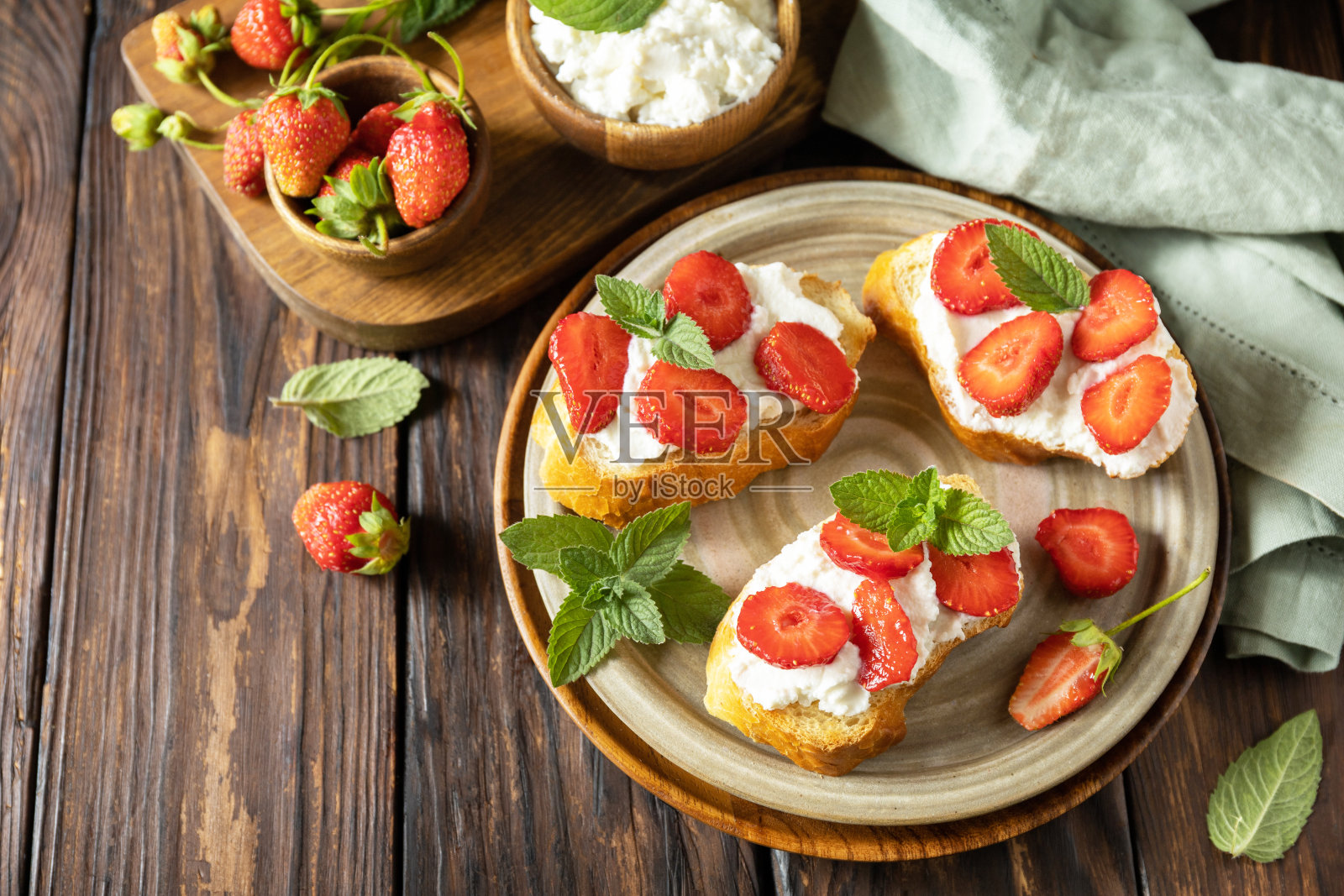 木制背景的草莓和软奶酪三明治。浆果吐司早餐，健康食品。副本的空间。照片摄影图片