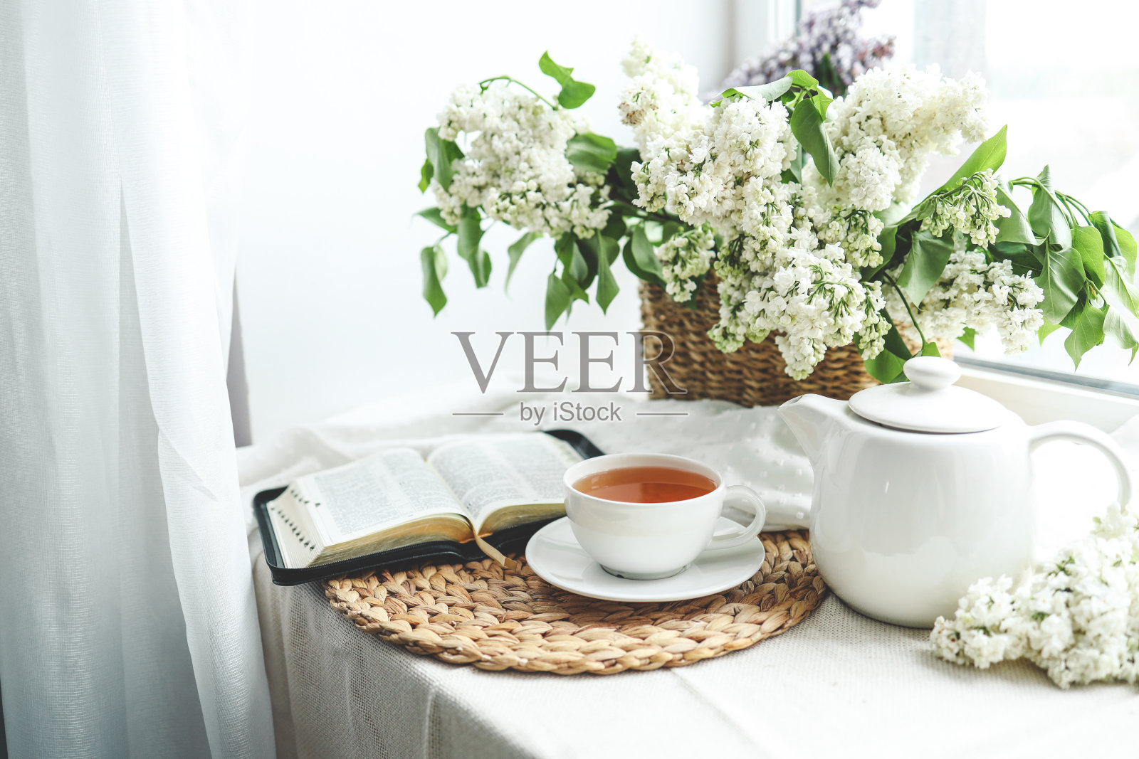 一杯茶，一篮紫丁香和一本打开的《圣经》照片摄影图片