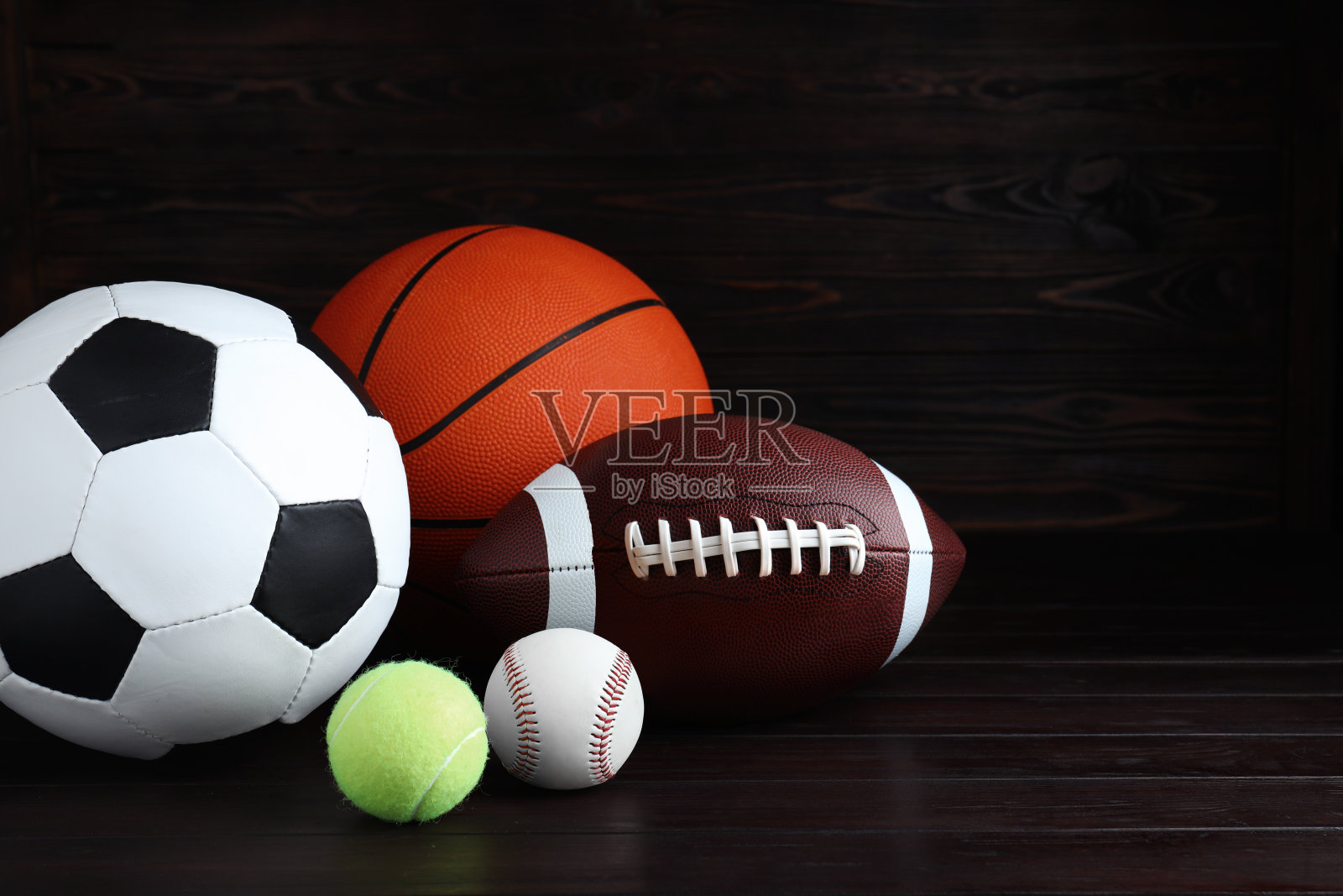 一套不同的运动球在木桌上。空间的文本照片摄影图片