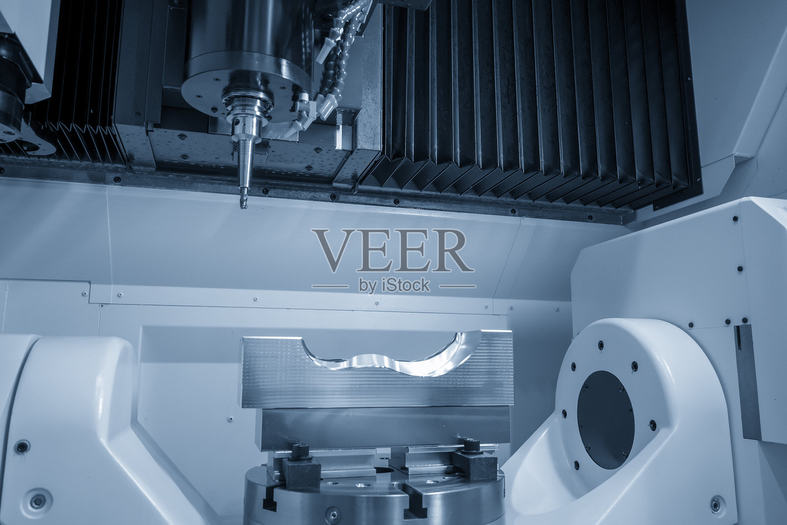 五轴加工中心工作台倾斜式通过可转位刀具对鞋类注射模具零件进行切割。照片摄影图片