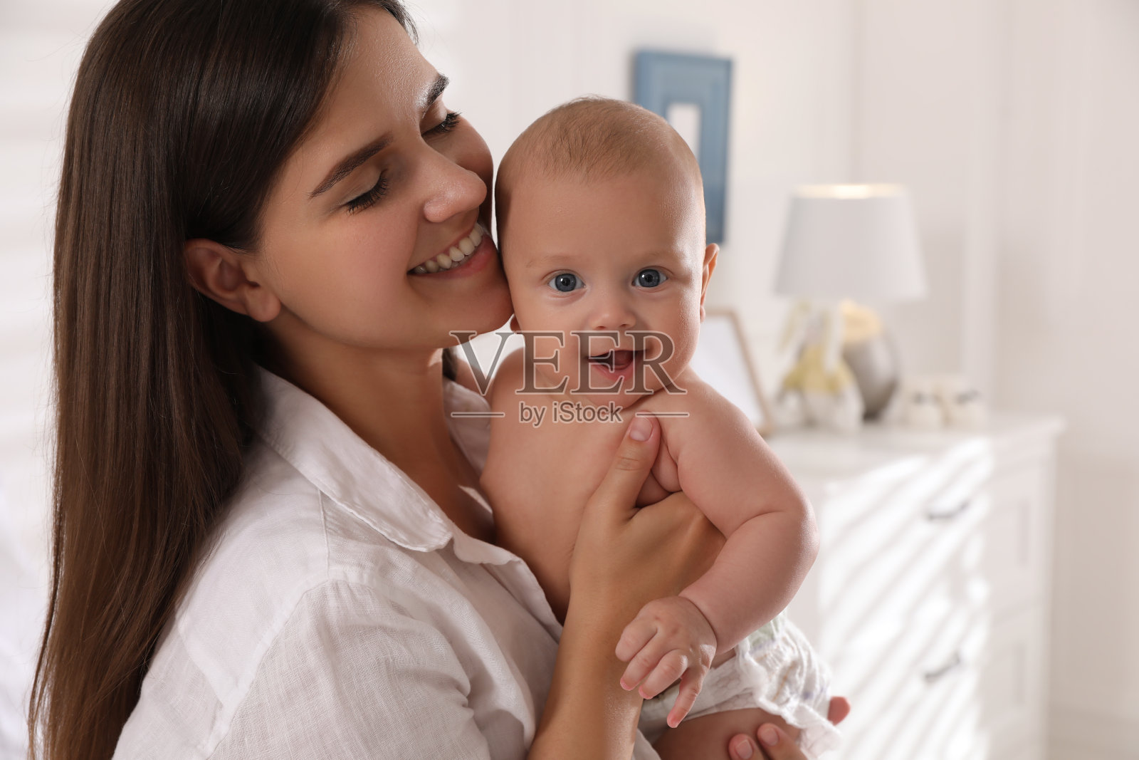 快乐的年轻妈妈和她可爱的宝宝在家里照片摄影图片