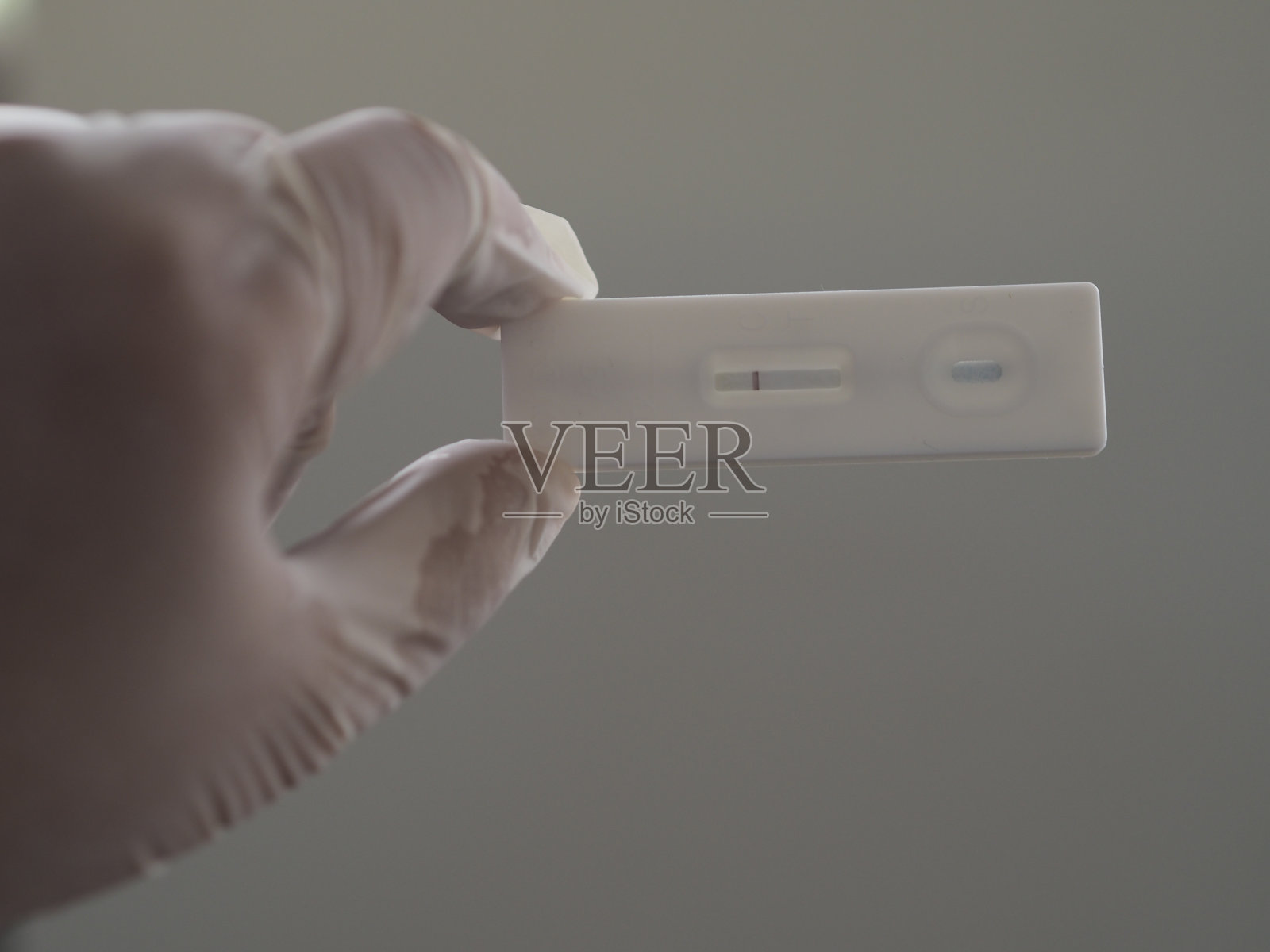 亚洲妇女戴橡胶手套持有ATK抗原检测试剂盒covid-19病毒检测照片摄影图片