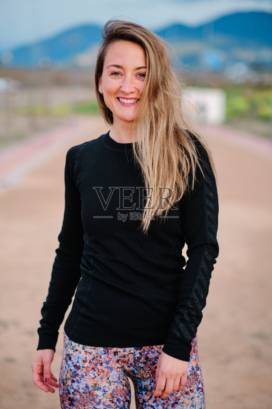 年轻的金发女子在公园里表演跑步和伸展运动照片摄影图片