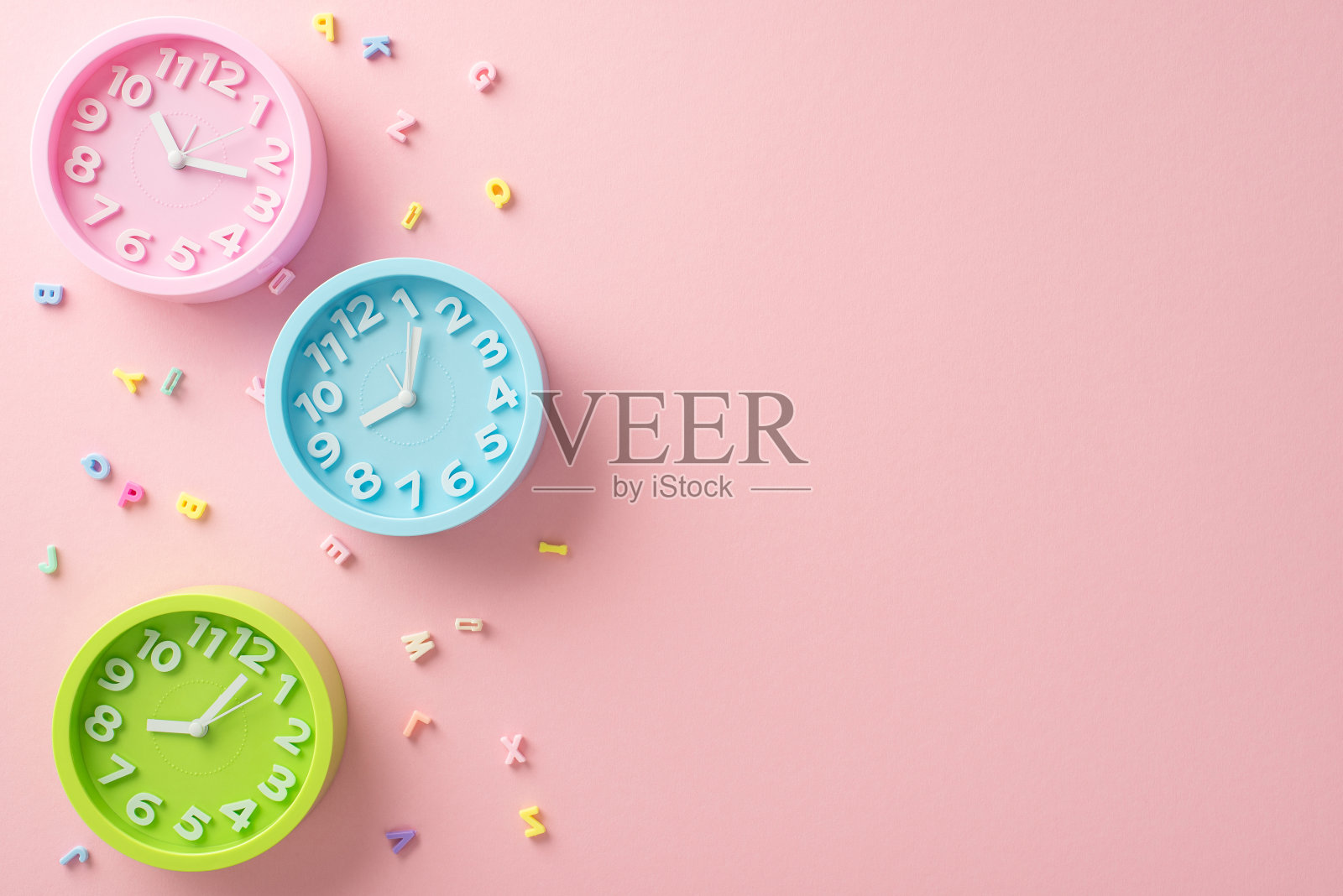 欢迎回到学校。俯视图字母和三个时钟设置为不同的时间，表示课程安排。粉彩粉色背景与空白空间的文字或广告的目的照片摄影图片