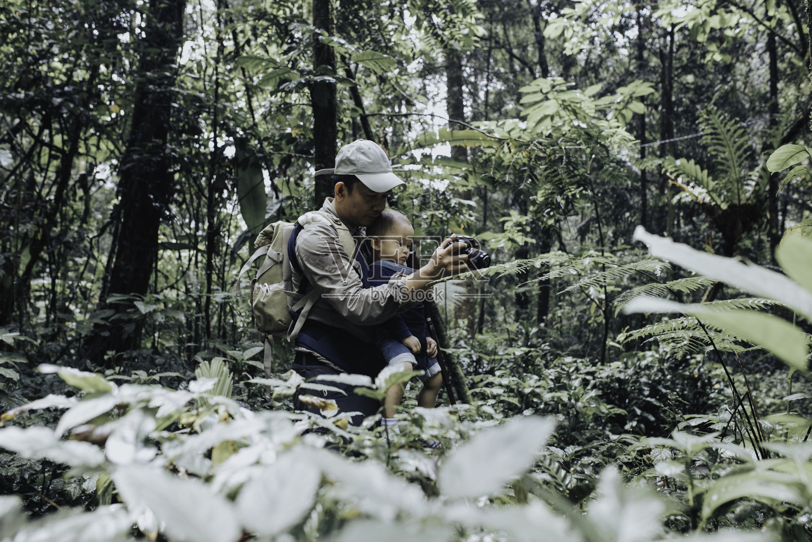 亚洲父母走在森林里与婴儿在春天的一天照片摄影图片