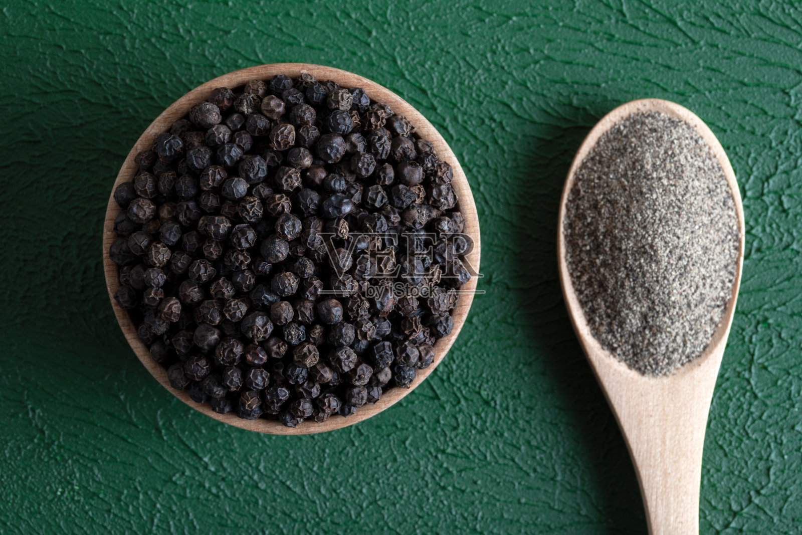 黑胡椒粒，绿色背景上有黑胡椒粒照片摄影图片