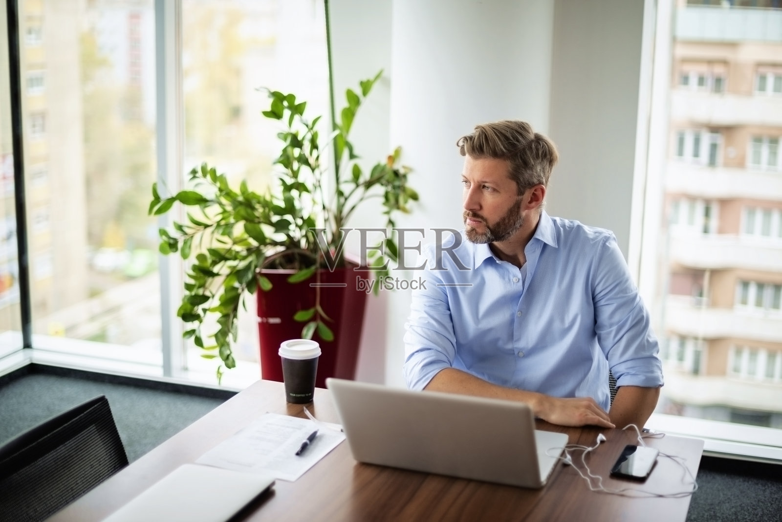 紧张的商人坐在办公桌旁，用笔记本电脑工作照片摄影图片