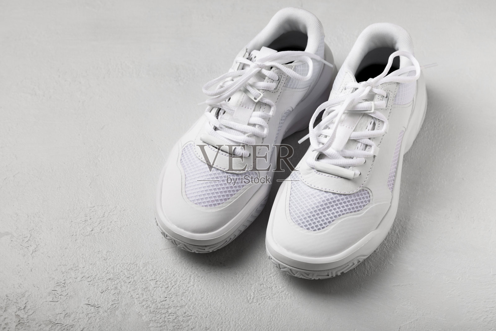 白色底白色运动鞋，时尚，男女皆宜。运动鞋是积极生活方式的运动鞋。产品照片和悬浮概念。街头风格。副本的空间。放文字的地方。照片摄影图片