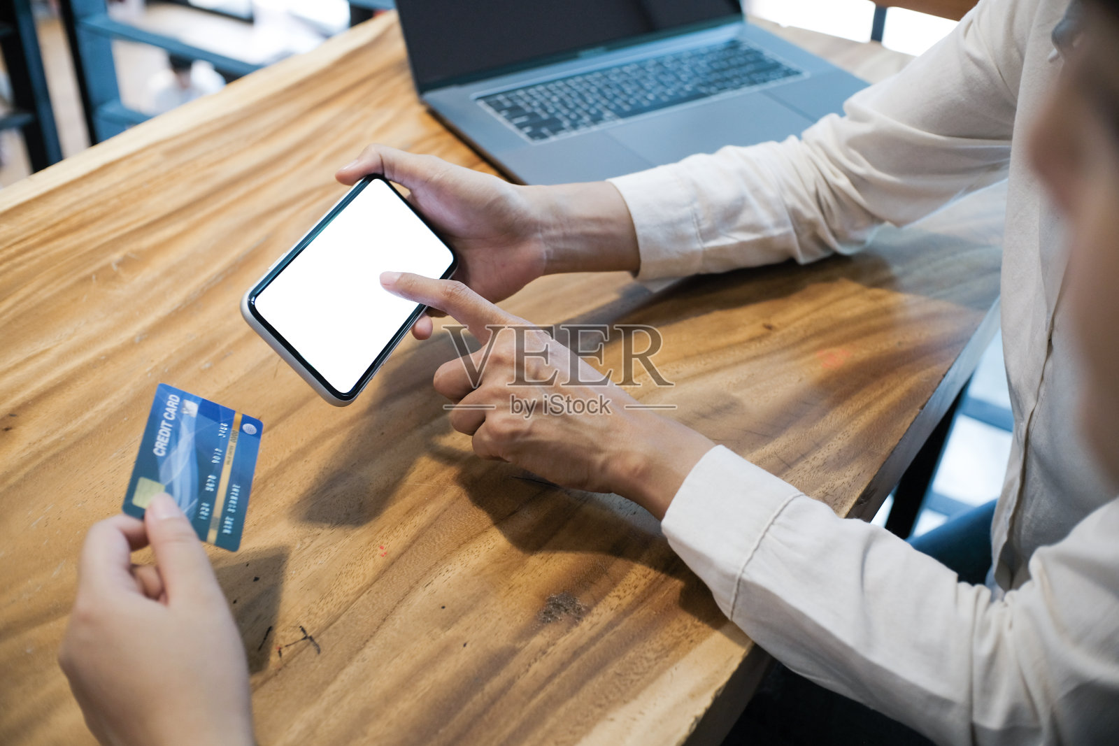 手持信用卡使用笔记本电脑的女性。网上购物的概念。照片摄影图片