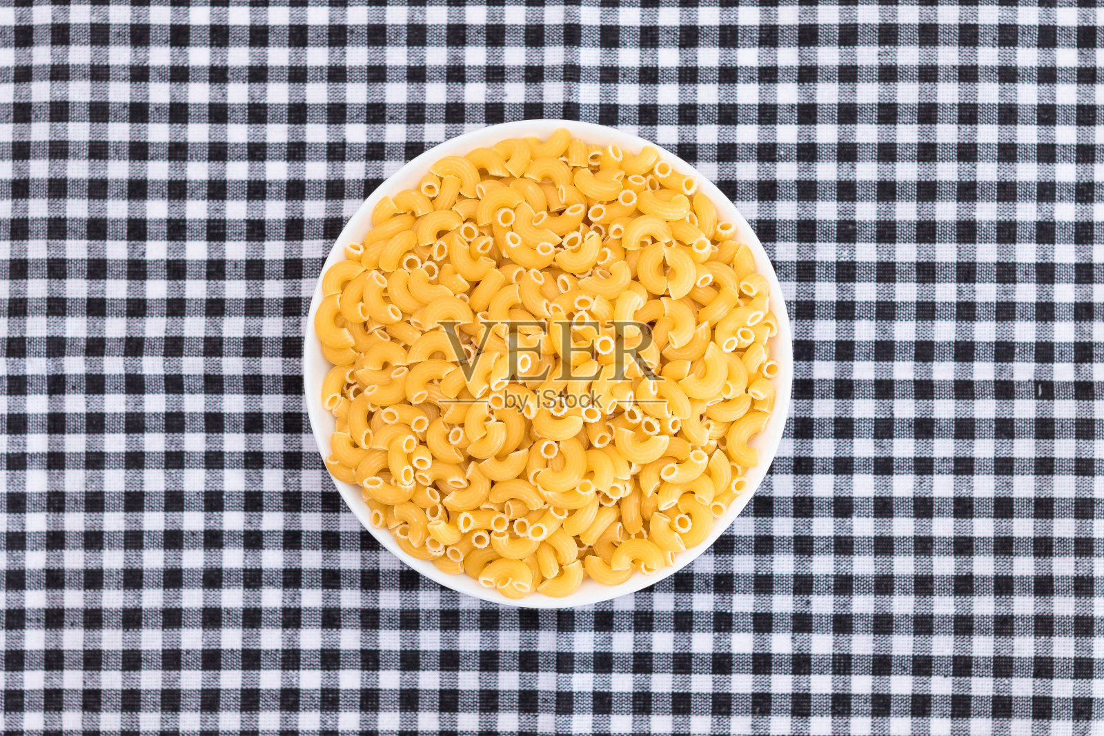 黑色方格毛巾上的白杯生意式意大利面照片摄影图片