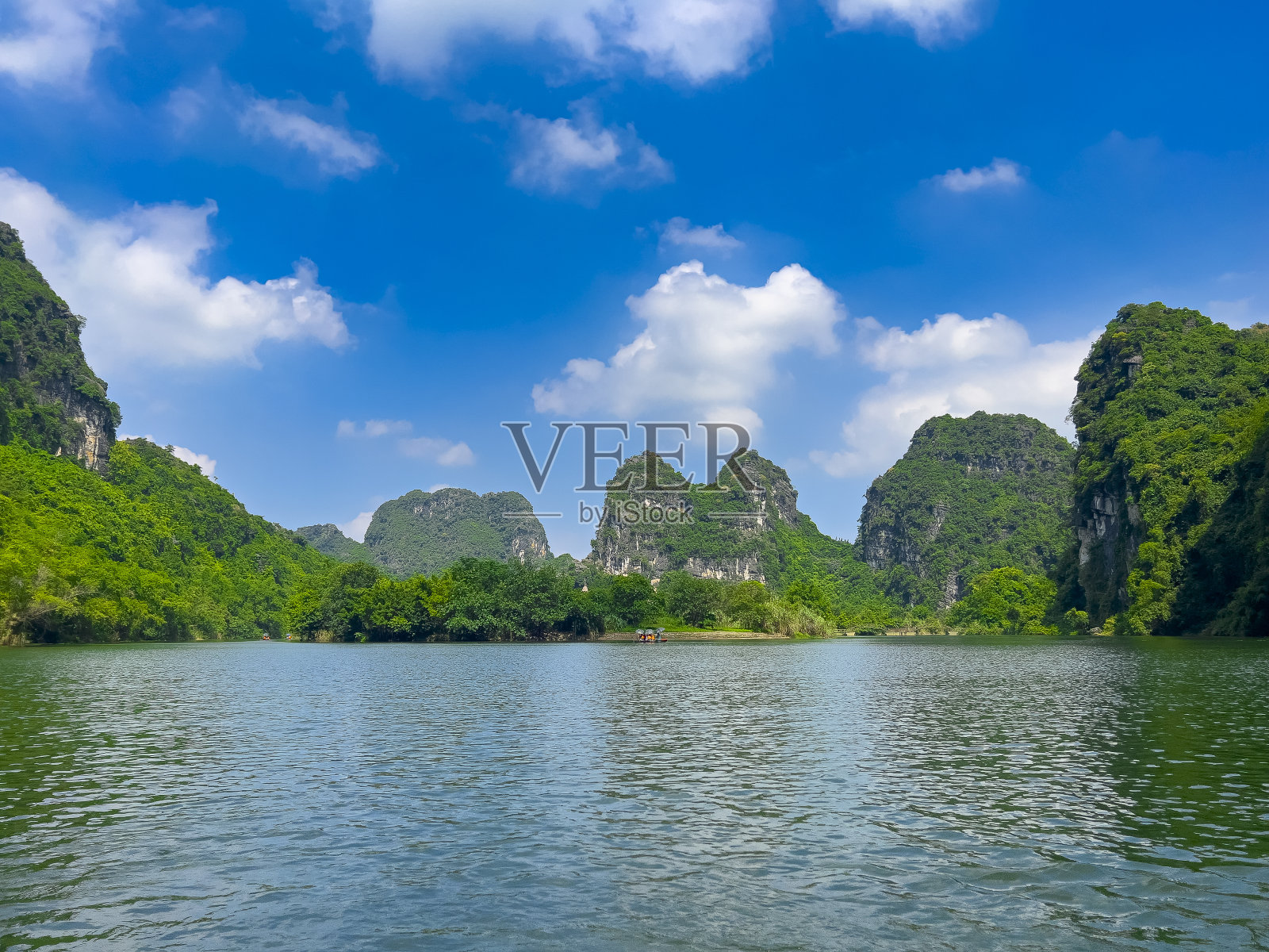 越南的庄安河、宁明和白定山距离河内只有3小时的车程。美丽蜿蜒的河流和高耸的高山。船穿过河中的洞穴照片摄影图片