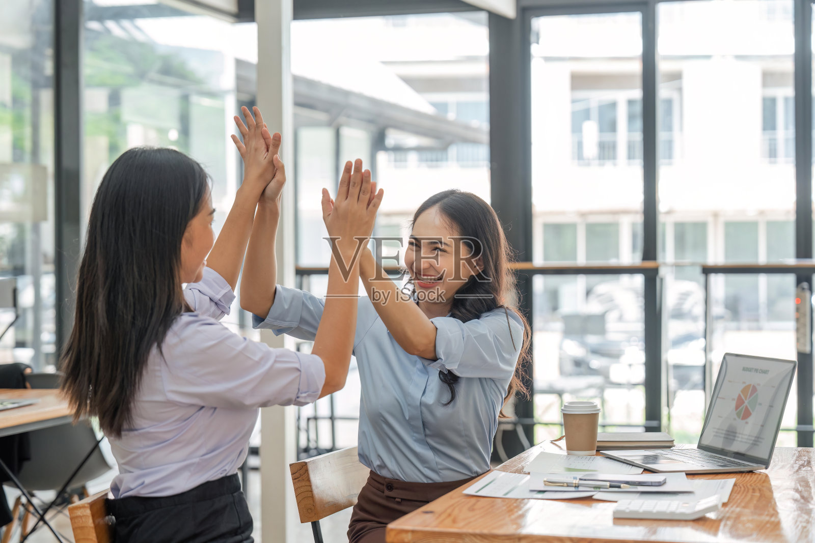 兴奋的亚洲商务团队在办公室会议上击掌庆祝胜利、成就或良好的工作成果照片摄影图片