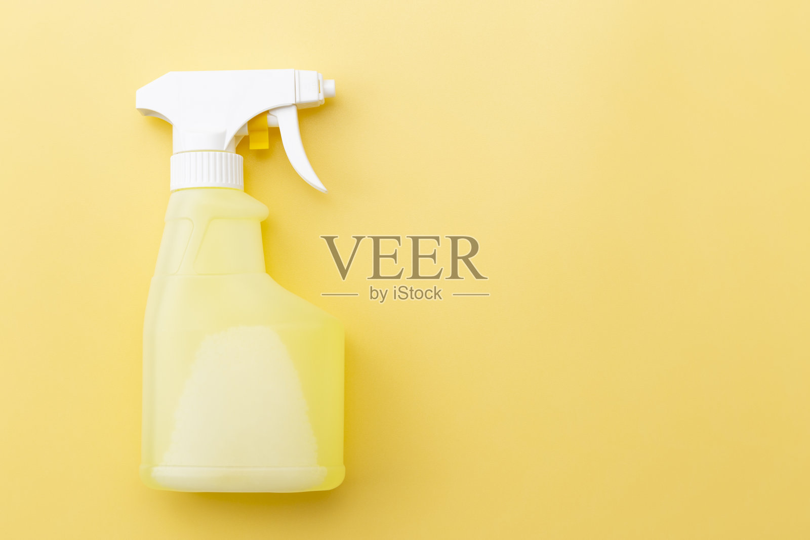 在黄色背景上喷洒清洁剂照片摄影图片