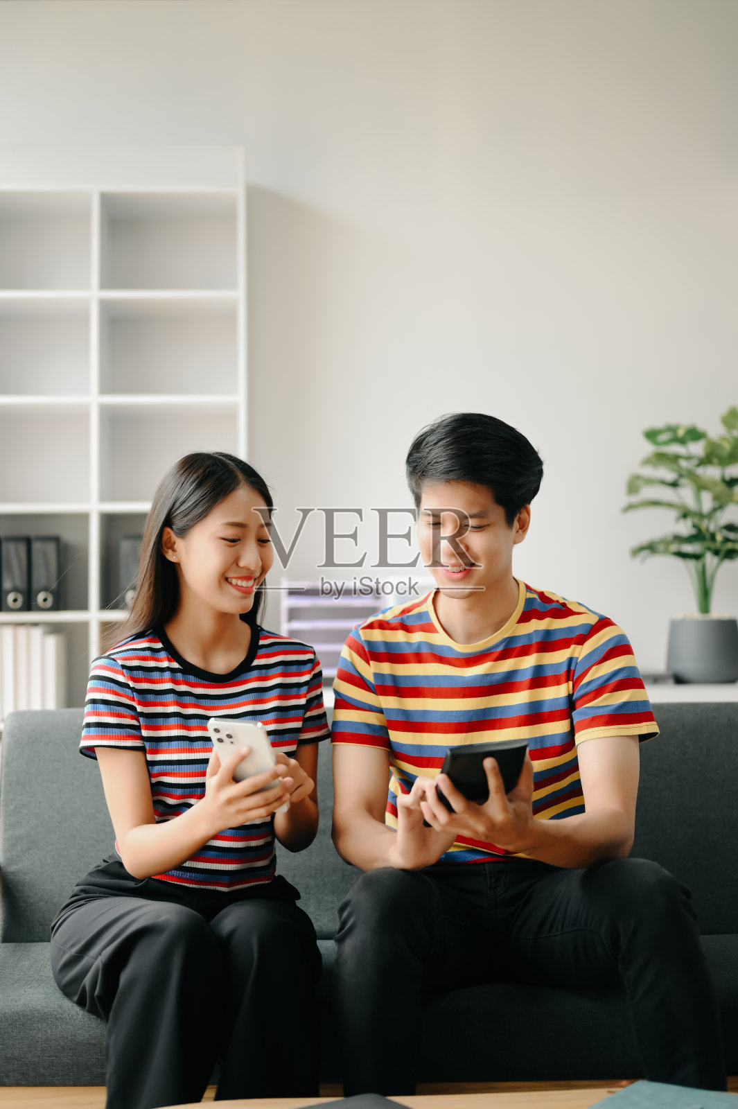 两个亚洲学生在客厅用笔记本电脑、平板电脑和导师一起在线学习照片摄影图片