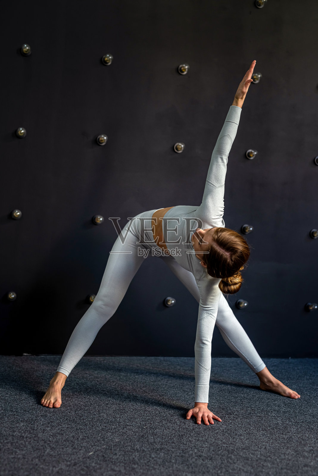 练习瑜伽的女性穿着运动服，按照瑜伽书上的姿势进行练习。照片摄影图片