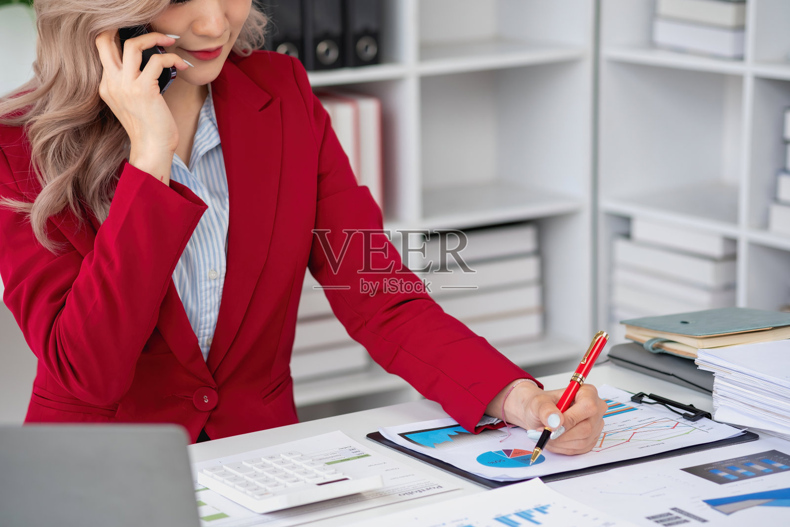 顾问，亚洲女商人在电话中讨论财务工作和营销商业计划，以增加公司利润，准备使用电脑和营销策划文件。照片摄影图片