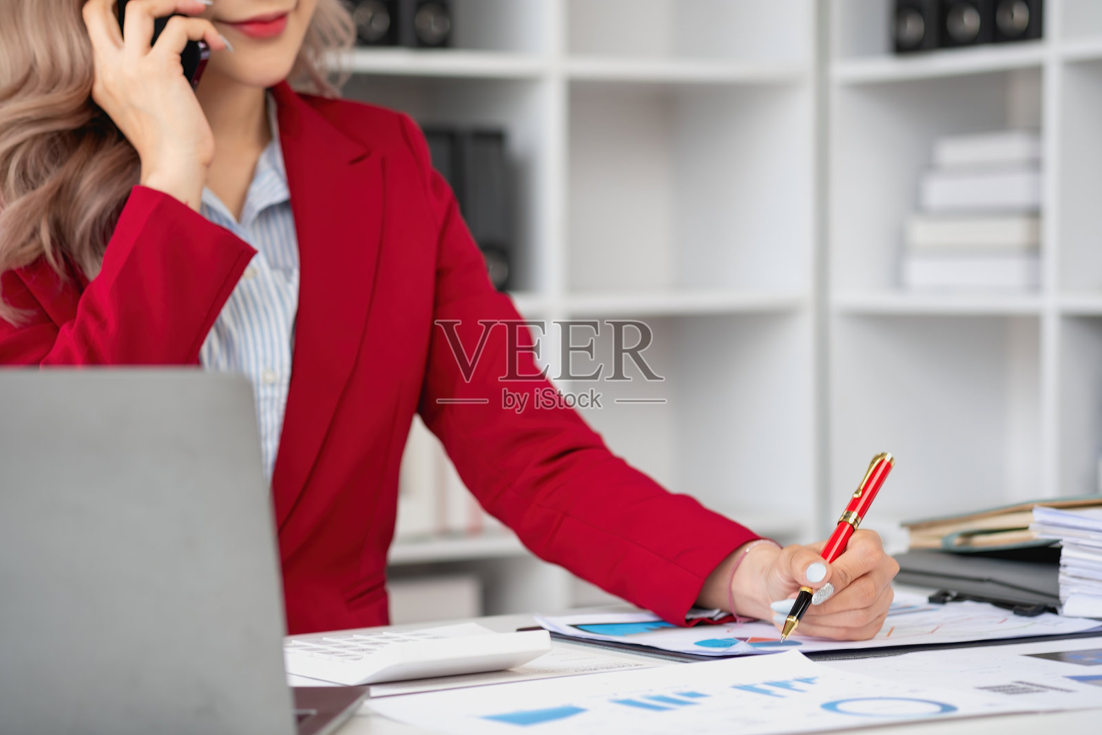 顾问，亚洲女商人在电话中讨论财务工作和营销商业计划，以增加公司利润，准备使用电脑和营销策划文件。照片摄影图片